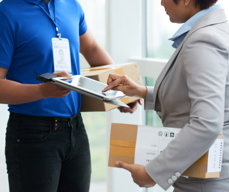 Man delivering package to lady customer signing on an electronic device